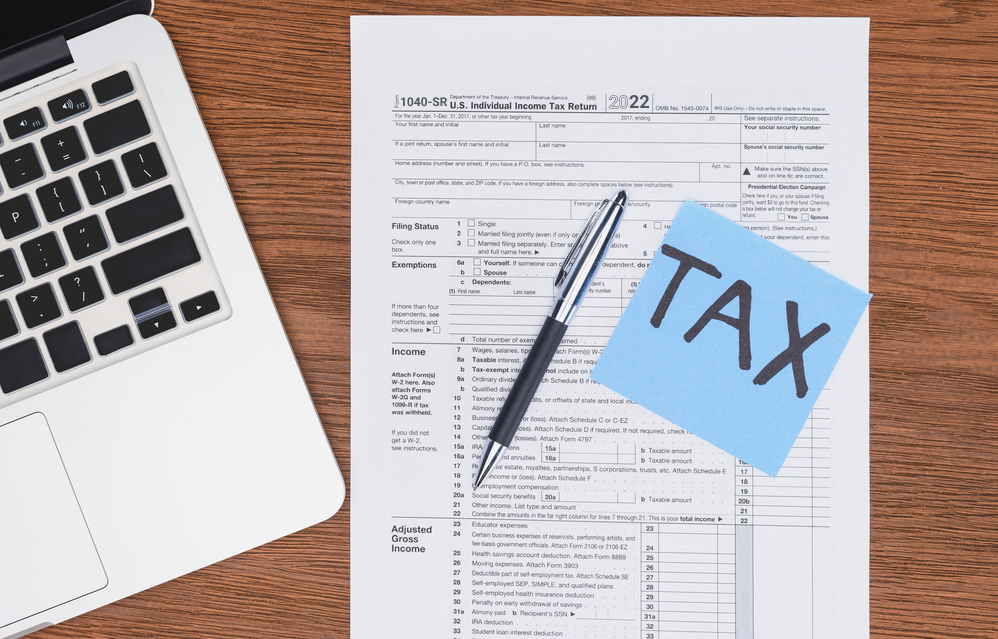 Form 1040-SR on a table with laptop